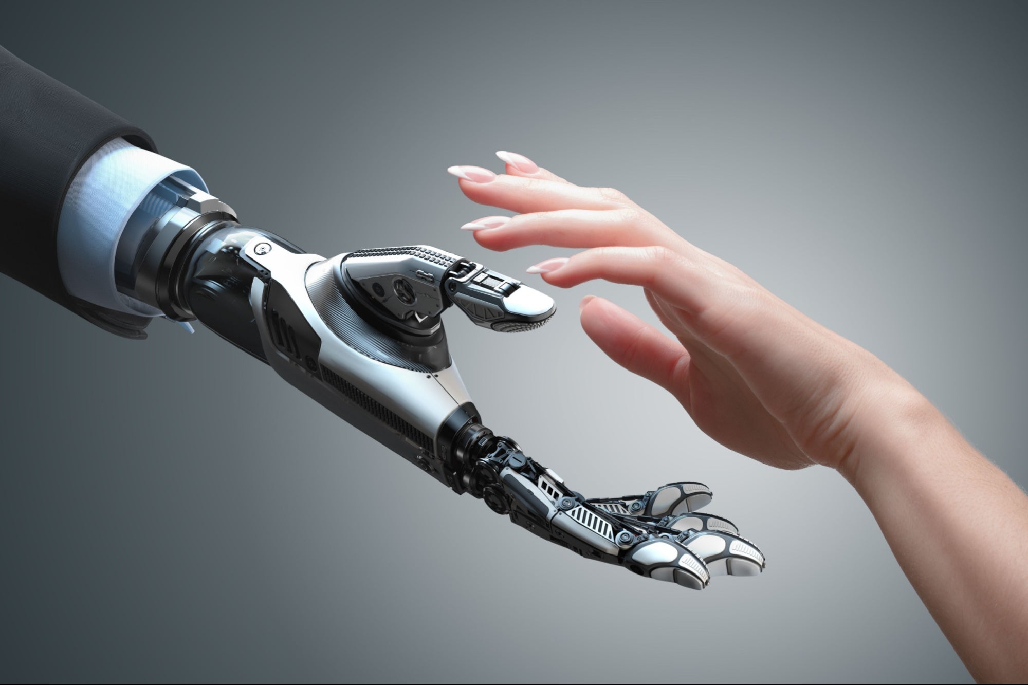 A robot hand and a human hand about to shake hands